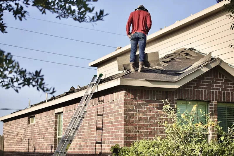 Professional roofer working on a residential roof in Derby Farms